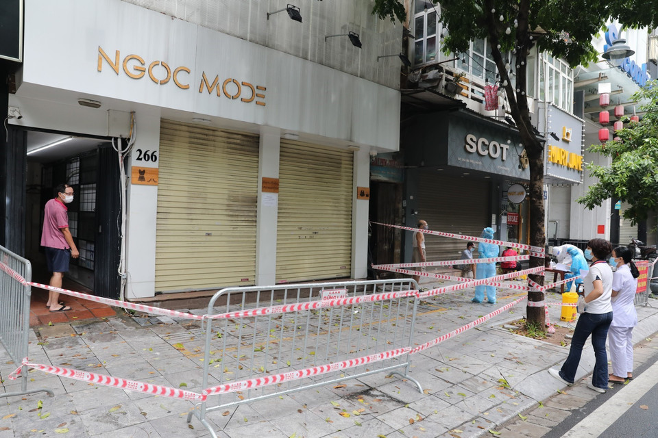Sau khi có thông tin 2 ca dương tính với SARS-CoV-2 ở 264 phố Bà Triệu, lực lượng chức năng phường Lê Đại Hành tiến hành phong tỏa các số nhà từ 260 đến 266 phố Bà Triệu. (Ảnh: Thành Đạt/TTXVN)
