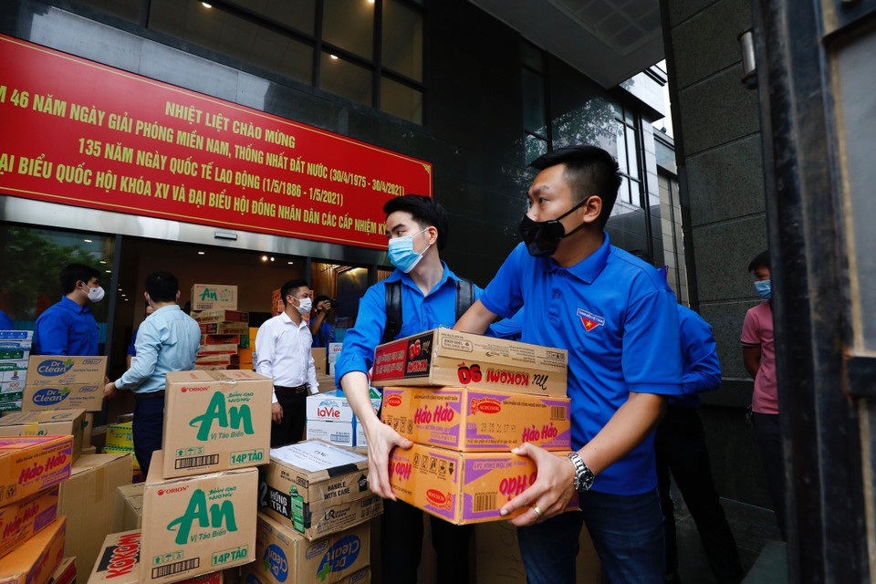Các đoàn viên, thanh niên Khối các cơ quan Trung ương vận chuyển nhu yếu phẩm lên xe đi hỗ trợ tỉnh Bắc Giang phòng chống dịch COVID-19. (Ảnh: Minh Đức/TTXVN)
