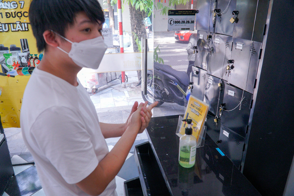 Salon bố trí nước sát khuẩn để khách hàng rửa tay trước khi vào quán. (Ảnh: Minh Hiếu/Vietnam+)
