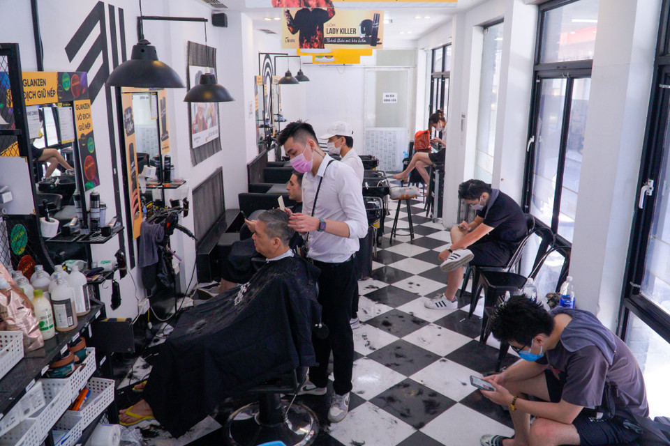 Theo ghi nhận của phóng viên, sau khi Hà Nội cho phép các quán cắt tóc được mở cửa trở lại, người dân đã đổ xô đi cắt tóc dẫn đến tình trạng một số salon tóc quá tải khách. (Ảnh: Minh Hiếu/Vietnam+)