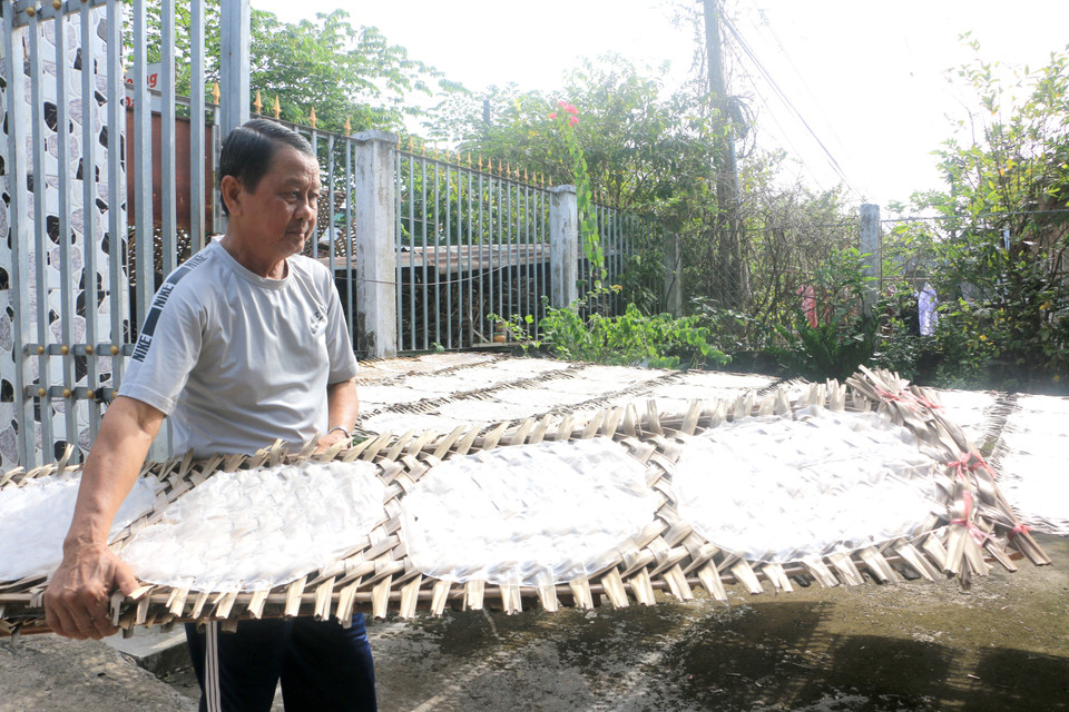 Người dân làng nghề bánh tráng Cù lao Mây tất bật phơi bánh để kịp giao cho khách. (Ảnh: Lê Thúy Hằng/TTXVN)