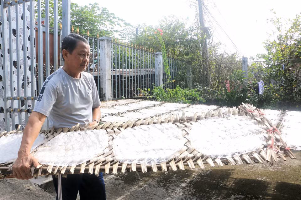 Người dân làng nghề bánh tráng Cù lao Mây tất bật phơi bánh để kịp giao cho khách. (Ảnh: Lê Thúy Hằng/TTXVN)