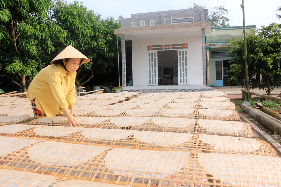 Người dân làng nghề bánh tráng Cù lao Mây tất bật phơi bánh để kịp giao cho khách. (Ảnh: Lê Thúy Hằng/TTXVN)