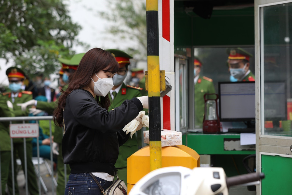 Người dân gửi đồ vào trong cho người thân đều phải kiểm tra cẩn thận đảm bảo an toàn phòng chống dịch. (Ảnh: Thành Đạt/TTXVN)