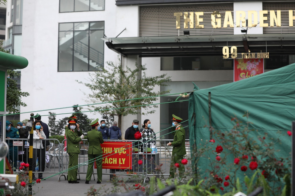 Lực lượng chức năng lập rào chắn, cách ly tòa nhà Garden Hill để đảm bảo công tác phòng chống dịch. (Ảnh: Thành Đạt/TTXVN)