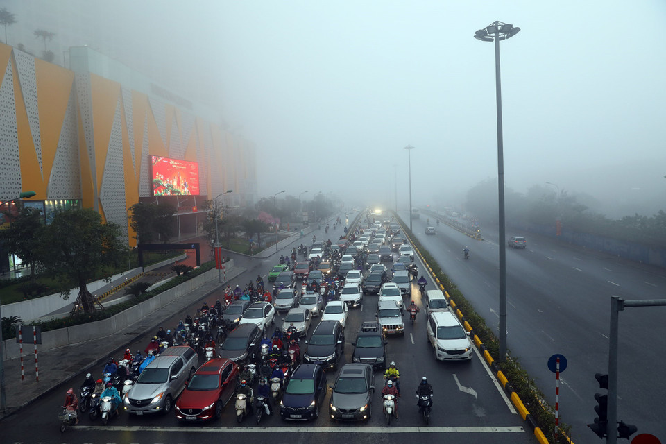 Trên tuyến phố Trân Duy Hưng, nhiều xe ôtô đi trên đường phải bật đèn khi di chuyển. (Ảnh: Minh Quyết/TTXVN)