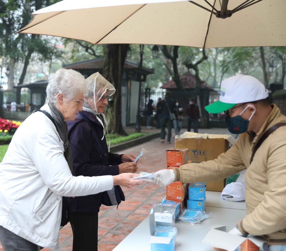 Phát khẩu trang miễn phí cho khách tham quan Di tích Quốc gia đặc biệt Văn Miếu-Quốc Tử Giám để phòng tránh dịch bệnh. (Ảnh: Thanh Tùng/TTXVN)