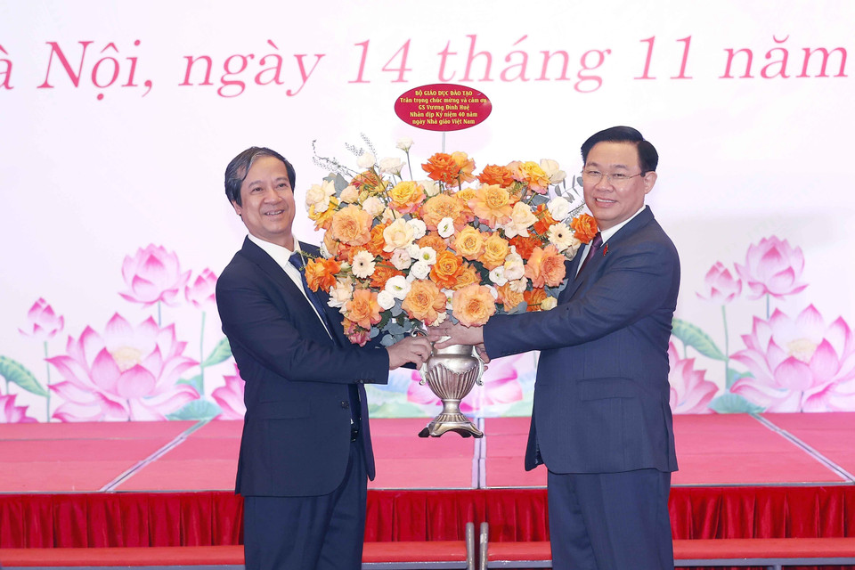Chủ tịch Quốc hội Vương Đình Huệ trao lẵng hoa đến Bộ trưởng Bộ Giáo dục và Đào tạo Nguyễn Kim Sơn, chúc mừng ngày Nhà giáo Việt Nam 20/11. (Ảnh: Doãn Tấn/TTXVN)