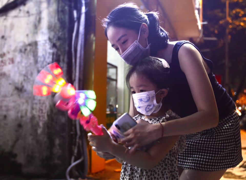 Để lưu giữ kỷ niệm đẹp cho con em, nhiều phụ huynh cố gắng tìm mua đồ chơi đón Tết Trung thu đang tới. (Ảnh: Hoàng Hiếu/TTXVN)