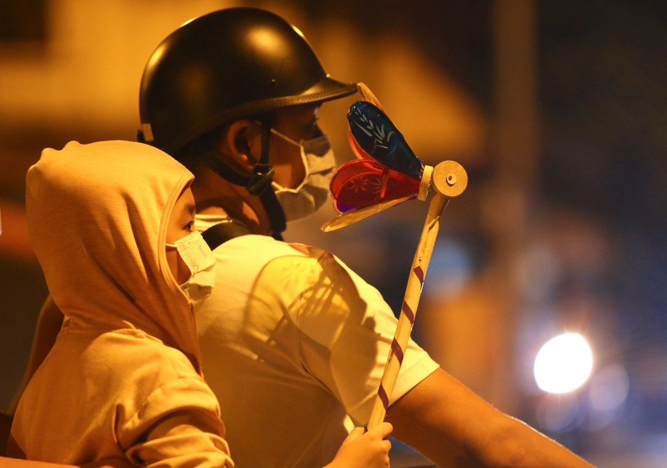 Một em bé thích thú với món đồ chơi mới được mua. (Ảnh: Hoàng Hiếu/TTXVN)