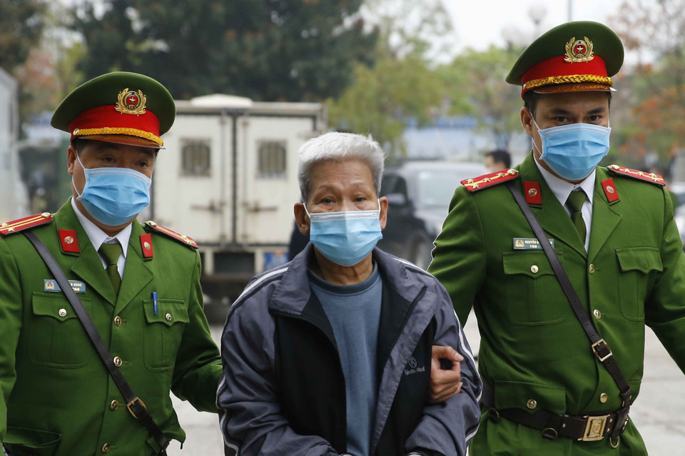 Cảnh sát dẫn giải các bị cáo vào phiên xét xử. (Ảnh: Doãn Tấn/TTXVN)