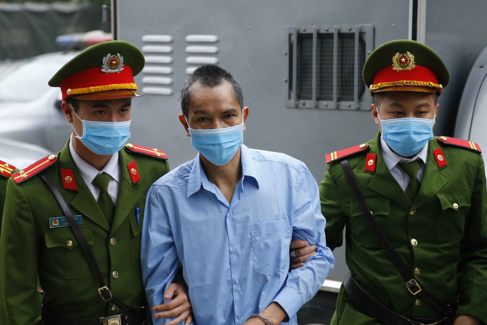 Cảnh sát dẫn giải các bị cáo vào phiên xét xử. (Ảnh: Doãn Tấn/TTXVN)