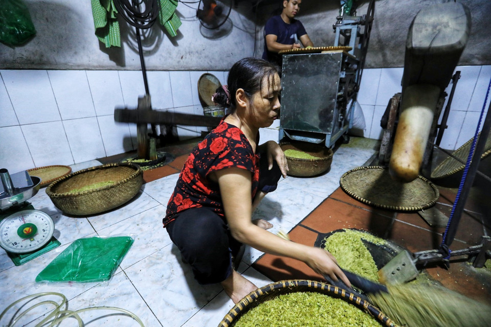 Quy trình giã cốm mất nhiều thời gian nhất. Thóc nguội chia thành từng mẻ nhỏ để giã. Cốm được giã tới 4 - 5 lần; sau mỗi lần giã người ta lại sàng, xảy để loại đi tạp chất trấu, cám và cứ làm như thế khi nào thấy cốm sạch thì thôi. (Ảnh: Thành Đạt/TTXVN)