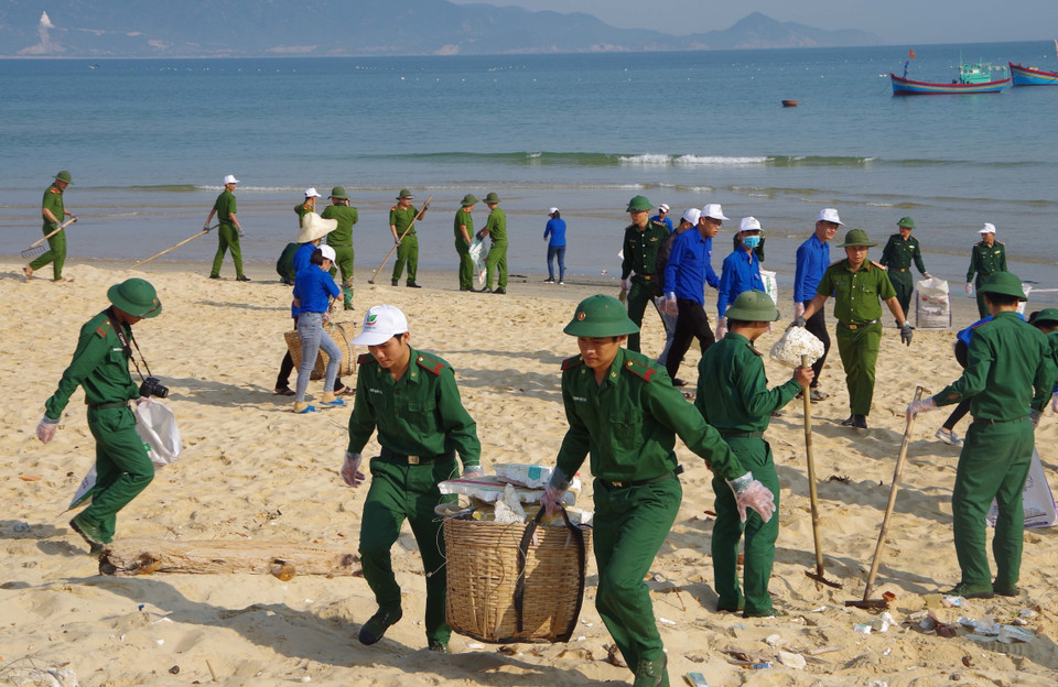 Đoàn viên thanh niên Bình Định chung tay dọn vệ sinh bãi biển Nhơn Lý. (Ảnh: Quốc Dũng/TTXVN)