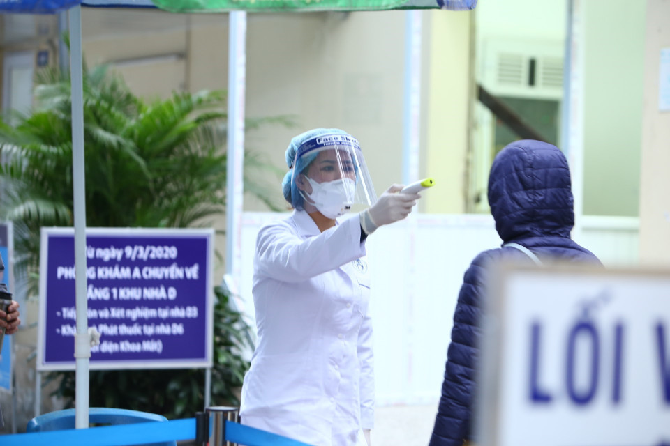 Người vào bệnh viện sẽ được kiểm tra thân nhiệt và khai báo lịch trình di chuyển. (Ảnh: Minh Quyết/TTXVN)