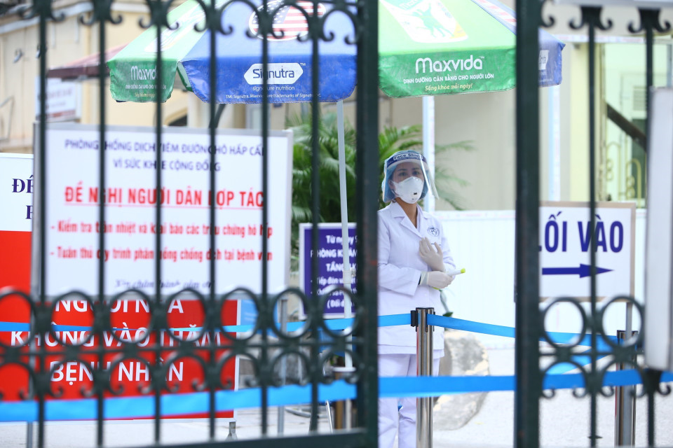 Bệnh viên luôn bố trí cán bộ y tế trực tại cửa kiểm tra thân nhiệt và hỏi về lịch trình di chuyển khi có người vào bệnh viện. (Ảnh: Minh Quyết/TTXVN)