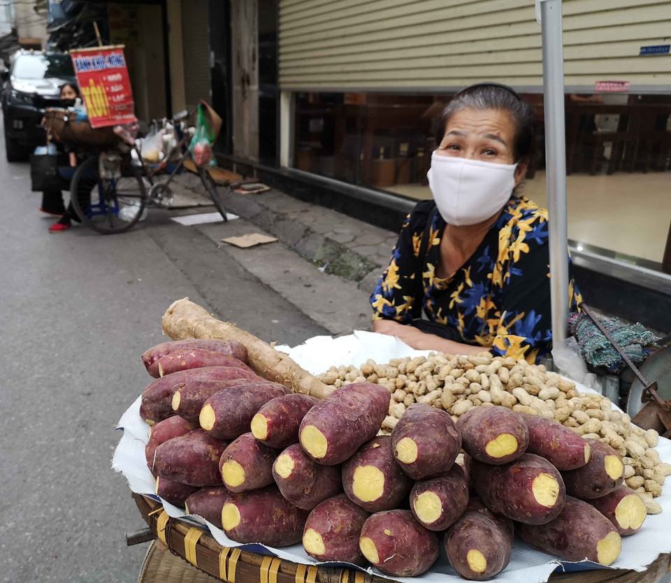 Một người bán hàng rong trong ngõ nhỏ đã ý thức đeo khẩu trang để phòng, chống dịch COVID-19. (Ảnh:TTXVN)