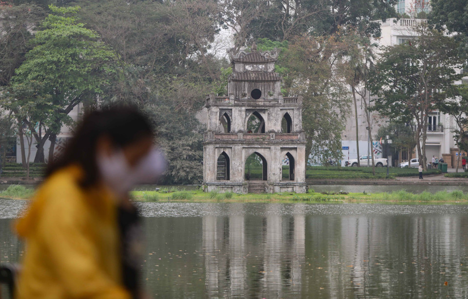 Hồ Hoàn Kiếm (Hà Nội) chỉ còn lác đác người dân đi dạo, tập thể dục song đều đeo khẩu trang để phòng dịch. (Ảnh:TTXVN)