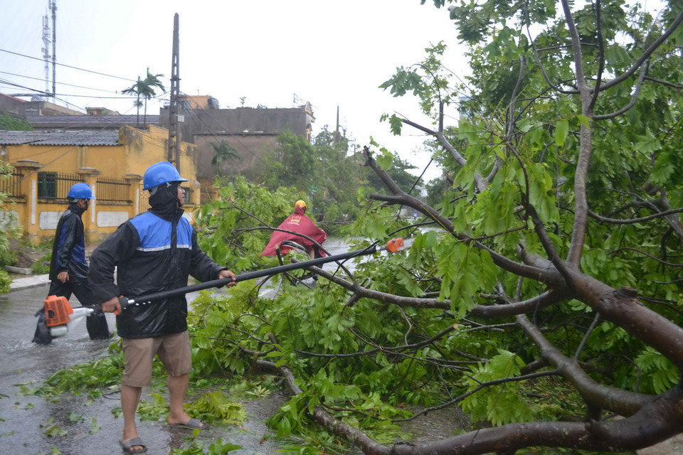 Người dân dọn dẹp sau bão. (Ảnh: Thu Hoài/TTXVN)