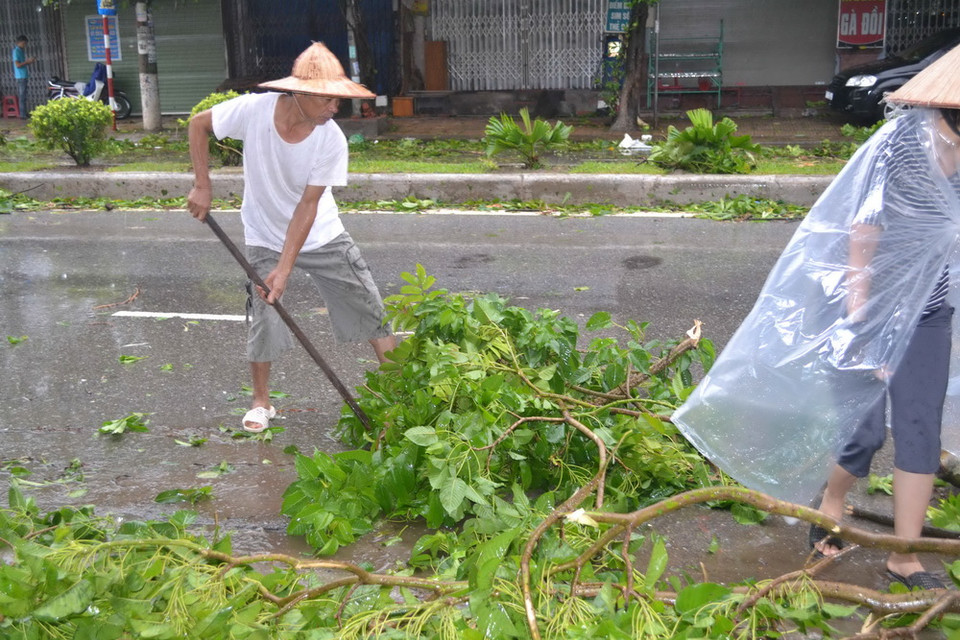 Người dân dọn dẹp sau bão. (Ảnh: Thu Hoài/TTXVN)