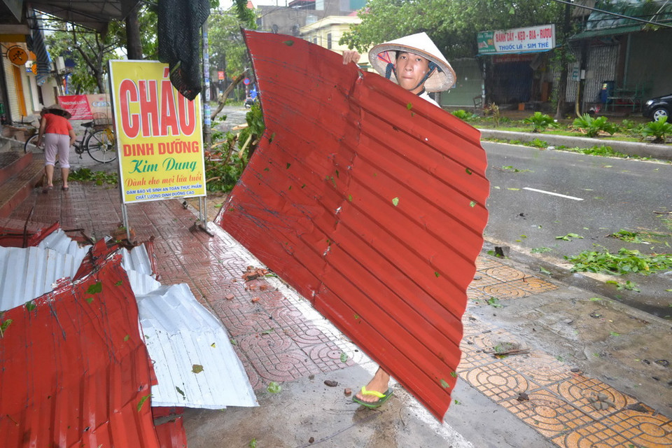 Người dân dọn dẹp sau bão. (Ảnh: Thu Hoài/TTXVN)