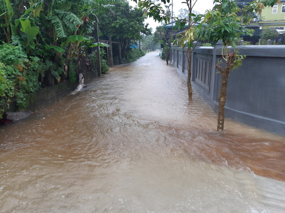 Nhiều đoạn đường vùng thấp trũng bị ngập cao, nước chảy siết. (Ảnh: Mai Trang/TTXVN)