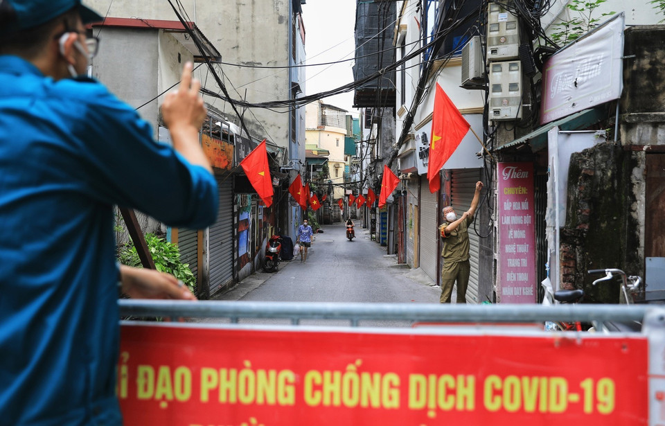 Tổ phòng, chống COVID cộng đồng phường Ngọc Hà, quận Ba Đình tổ chức treo cờ Tổ quốc cho các hộ gia đình. (Ảnh: Thành Đạt/TTXVN)