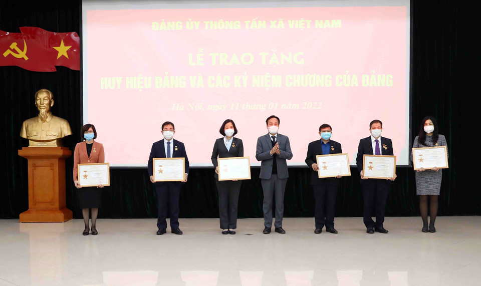 Đồng chí Lại Xuân Lâm, Phó Bí thư Đảng ủy Khối các Cơ quan Trung ương, trao tặng Kỷ niệm chương Vì sự nghiệp xây dựng Đảng ủy Khối cho các lãnh đạo, cán bộ TTXVN. (Ảnh: Phạm Kiên/TTXVN)