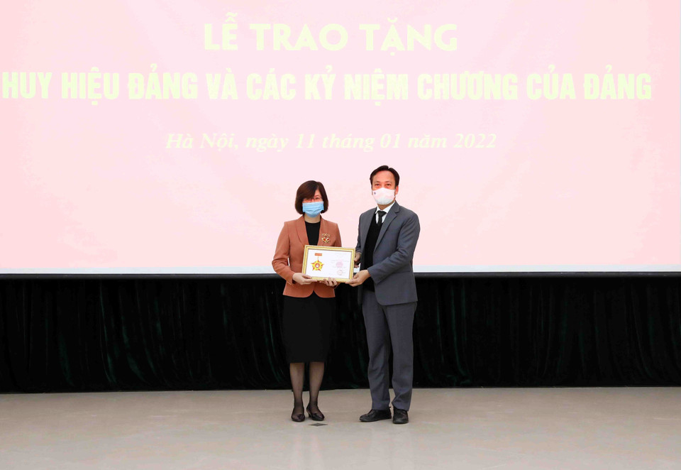 Đồng chí Lại Xuân Lâm, Phó Bí thư Đảng ủy Khối các Cơ quan Trung ương, trao tặng kỷ niệm chương Vì sự nghiệp công tác tổ chức xây dựng Đảng cho đồng chí Hà Thị Mai An, Phó Bí thư chuyên trách Đảng ủy TTXVN. (Ảnh: Phạm Kiên/TTXVN)