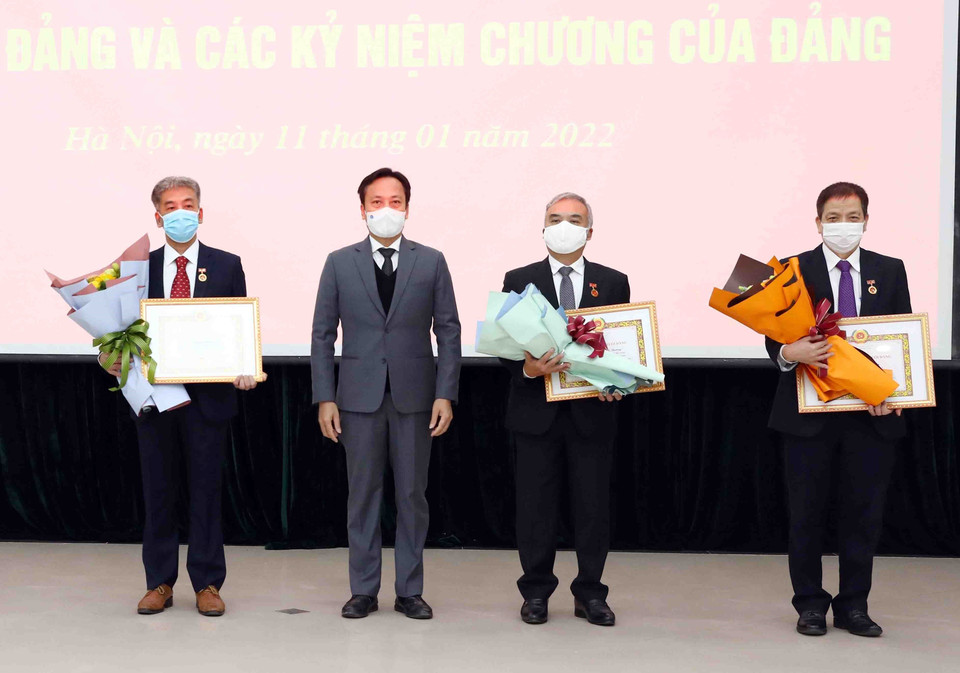 Đồng chí Lại Xuân Lâm, Phó Bí thư Đảng ủy Khối các Cơ quan Trung ương, trao tặng Huy hiệu 30 năm tuổi Đảng cho các Đảng viên là nguyên lãnh đạo, cán bộ TTXVN. (Ảnh: Phạm Kiên/TTXVN)