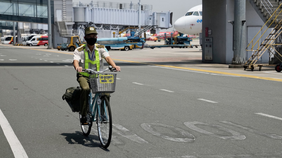 Một nhân viên an ninh kiểm soát sân đỗ tàu bay đang đi tuần tra. (Ảnh: CTV/Vietnam+)
