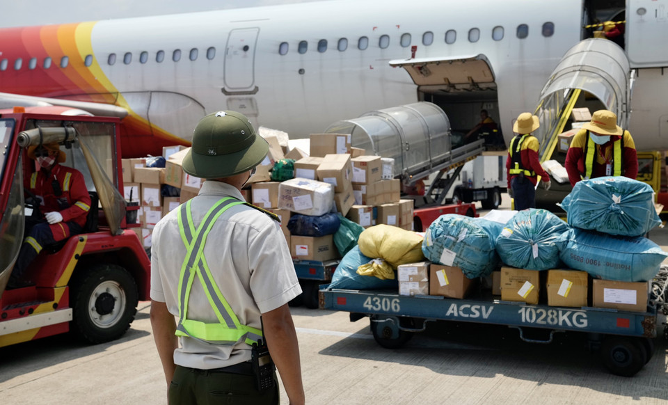 Trên đường tuần tra, nếu gặp các chuyến bay đang khai thác, nhân viên an ninh hàng không sẽ dừng lại để kiểm tra những nhân viên phục vụ tàu bay. (Ảnh: CTV/Vietnam+)