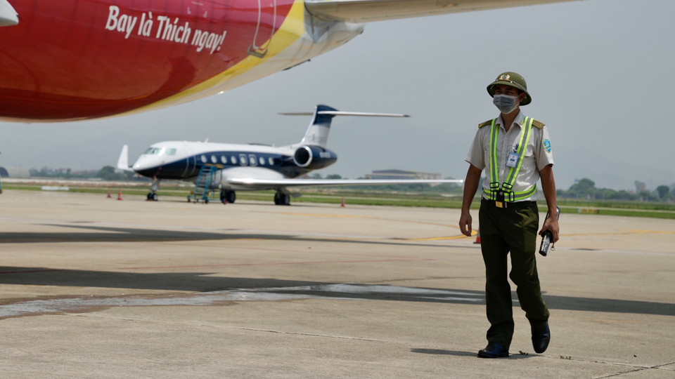 Nhân viên An ninh hàng không làm việc dưới nền bê tông hấp thụ nhiệt từ mặt trời và khí thải của động cơ tàu bay. (Ảnh: CTV/Vietnam+)