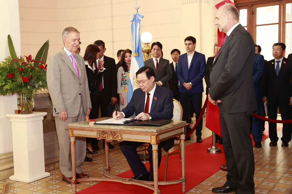 Chủ tịch Quốc hội Vương Đình Huệ viết sổ lưu niệm. (Ảnh: Doãn Tấn/TTXVN)