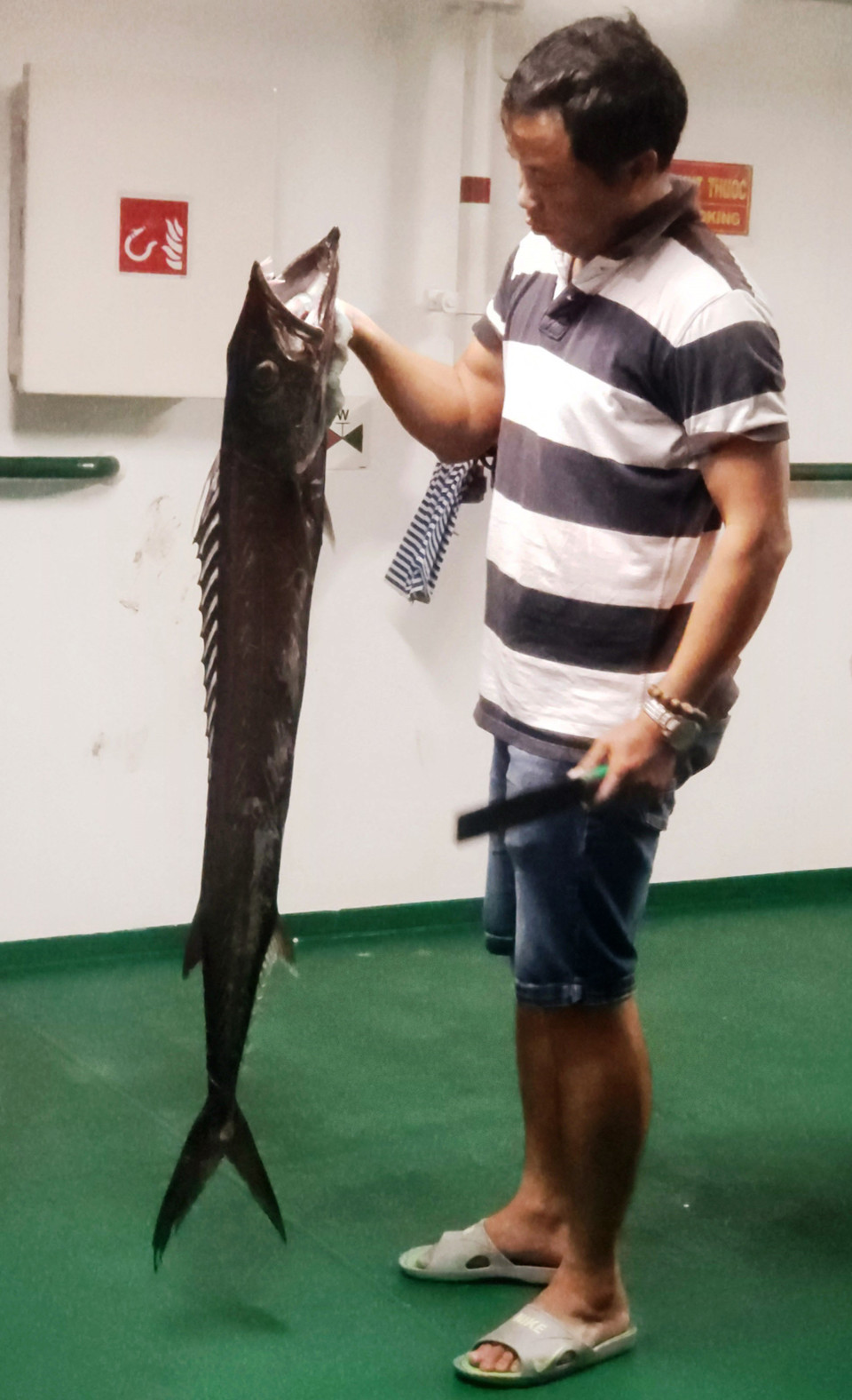 Cần thủ với chú cá ma vừa câu được. (Ảnh: Hoàng Hùng/TTXVN)