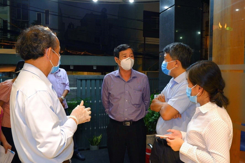 Phó giám đốc Sở Y tế Thành phố Hồ Chí Minh Nguyễn Hữu Hưng (giữa) trực tiếp đến chỉ đạo phòng chống dịch tại khu vực đường Đặng Văn Ngữ rạng sáng 27/5. (Ảnh: TTXVN phát)