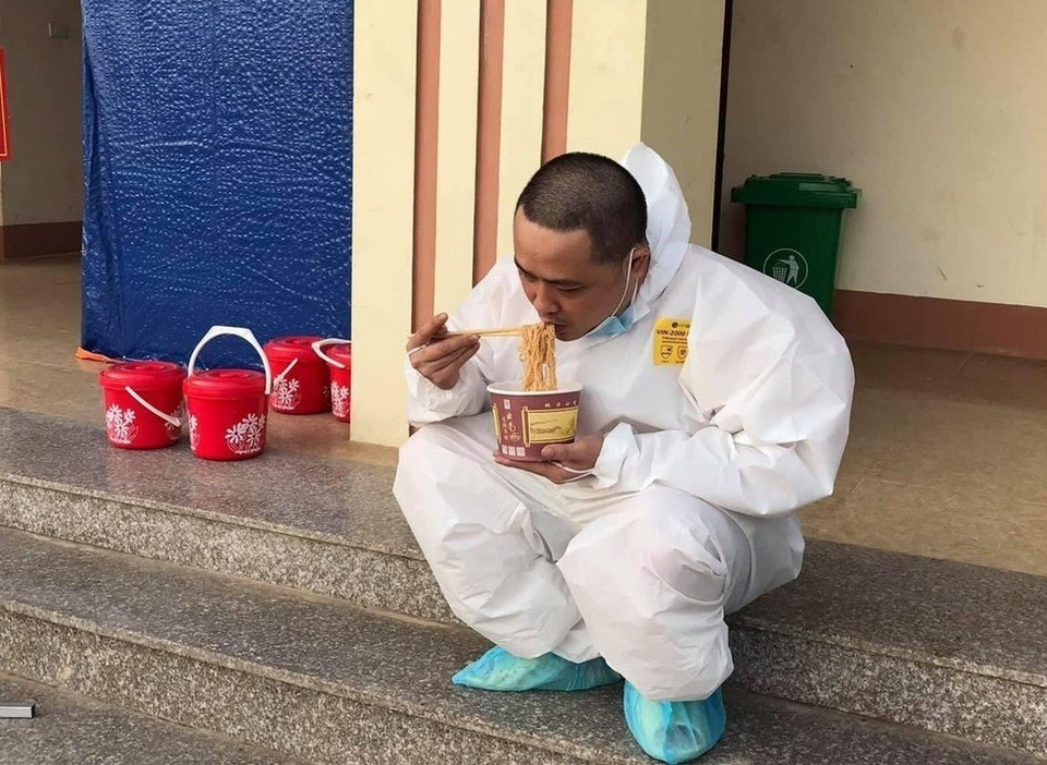 Y sỹ Hà Quang Huy, Bệnh viện Y học cổ truyền Yên Bái tranh thủ ăn trưa tại khu cách ly số 7. (Ảnh: TTXVN)