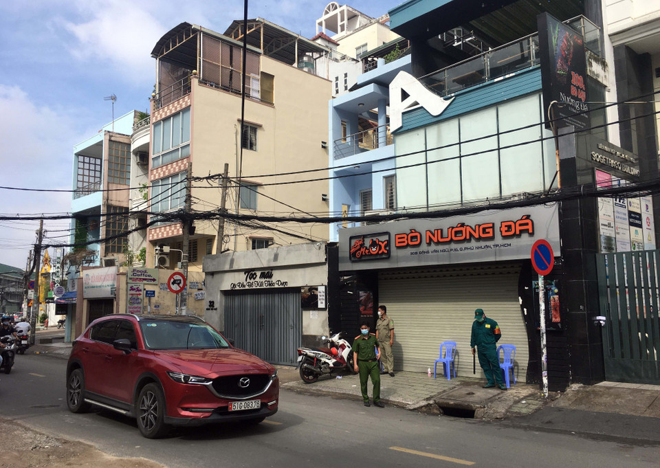Các cơ quan chức năng thực hiện phong tỏa tất cả hàng quán khu vực xung quanh tòa nhà số 30 đường Đặng Văn Ngữ, phường 10, quận Phú Nhuận. (Ảnh: Thanh Vũ/TTXVN)