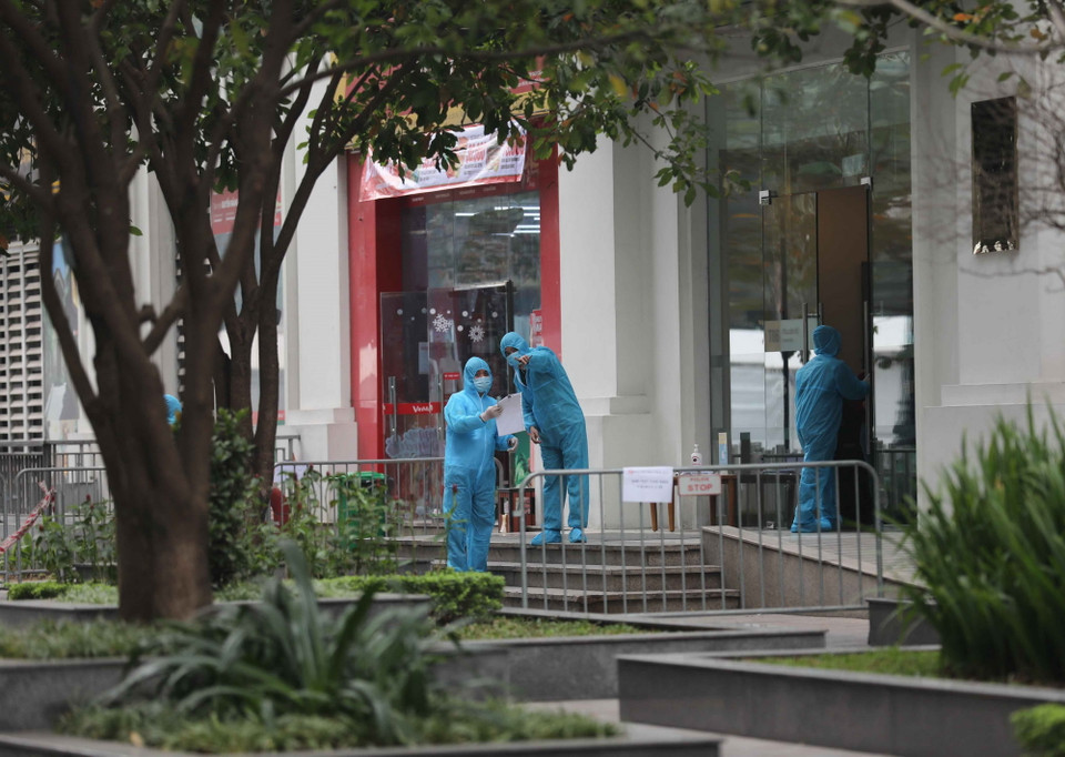  Lực lượng y tế và các lực lượng chức năng thực hiện nhiệm vụ bên ngoài tòa chung cư T6 ở Times City. (Ảnh: Thanh Tùng/TTXVN)