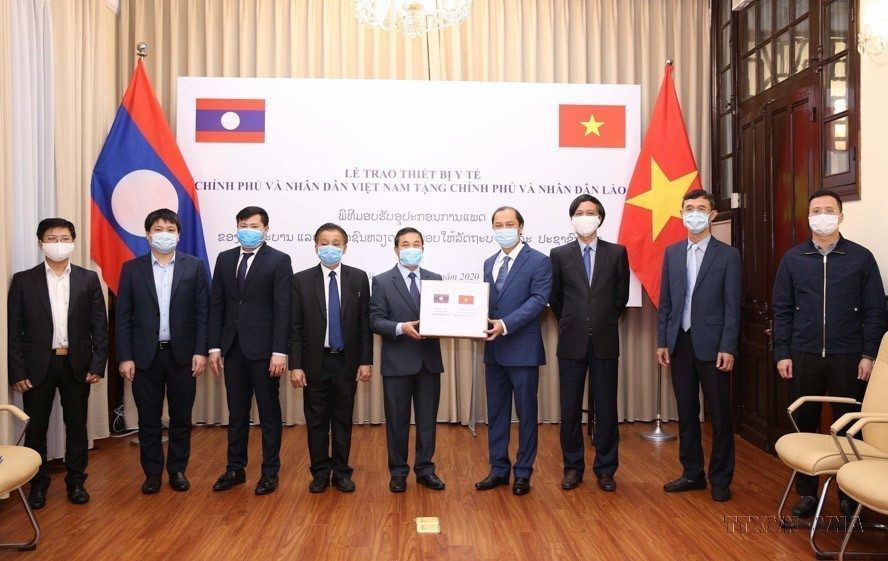 Thứ trưởng Bộ Ngoại giao Nguyễn Quốc Dũng trao tặng trang thiết bị y tế của Chính phủ và nhân dân Việt Nam cho Chính phủ và nhân dân Lào phòng chống COVID-19 (3/4/2020). (Ảnh: Dương Giang/TTXVN)