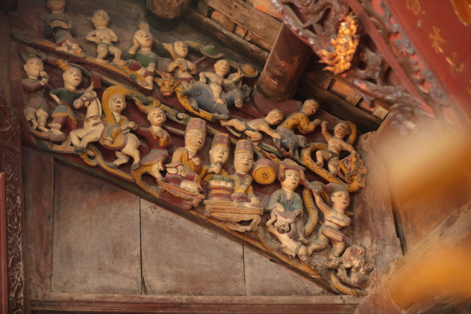 Bên trong đại đình, trên các cột kèo có nhiều bức phù điêu, tranh vẽ các tích như Đinh Bộ Lĩnh tập trận, Ông lão câu cá. (Ảnh: Minh Quyết/TTXVN)