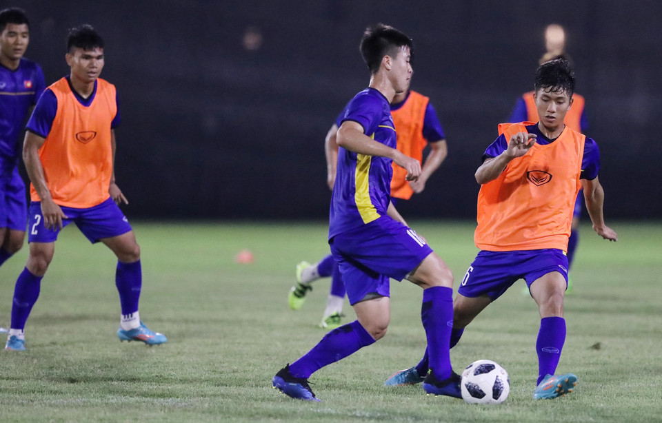 Văn Đức (áo cam) tranh bóng với Duy Mạnh (trái) tại buổi tập chiều 21/8. (Ảnh: Hoàng Linh/TTXVN)
