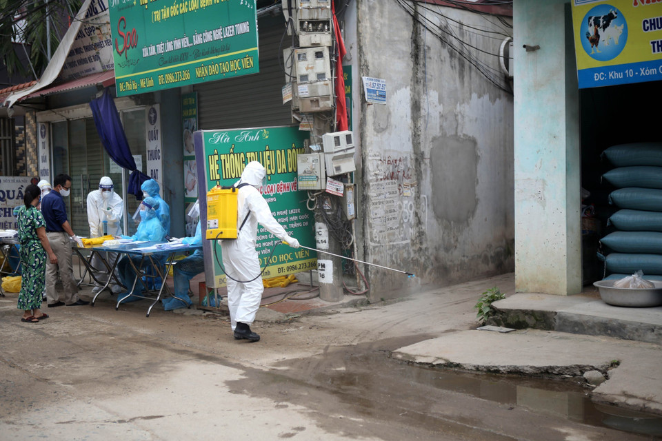 Phun thuốc khử khuẩn sau khi kết thúc công việc lấy mẫu xét nghiệm tại thôn Hạ Lôi (xã Mê Linh, huyện Mê Linh). (Ảnh: Danh Lam/TTXVN)