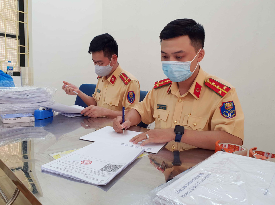 Giấy đi đường của từng cơ quan, đơn vị sẽ được cho vào phong bì và được lực lượng Cảnh sát dẫn đoàn vận chuyển trả đến từng sở ngành. (Ảnh: Phạm Kiên/TTXVN)