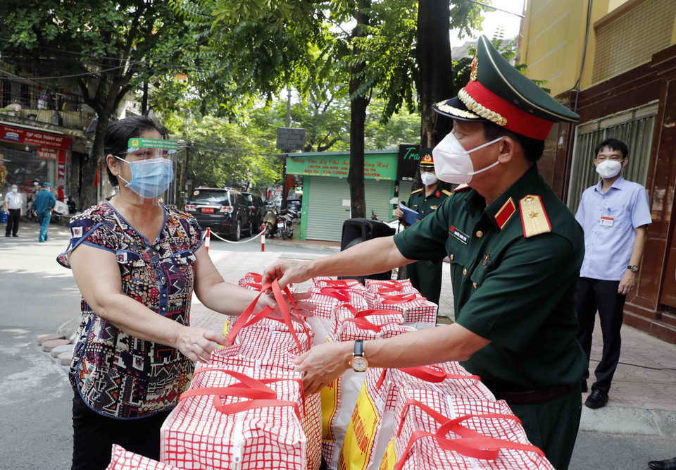 Đại diện hộ gia đình có hoàn cảnh khó khăn phường Thanh Xuân Bắc nhận những món quà từ Bộ Tư lệnh Cảnh sát biển và Bộ Tư lệnh Thủ đô. (Ảnh: Trần Việt/TTXVN)