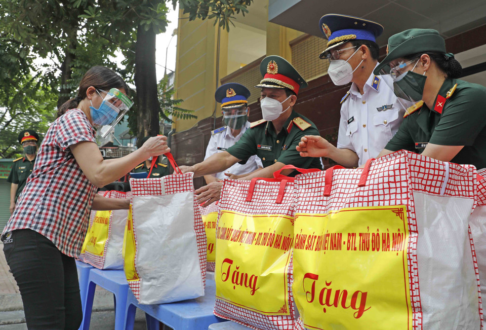 Đại diện hộ gia đình có hoàn cảnh khó khăn phường Thanh Xuân Bắc nhận những món quà từ Bộ Tư lệnh Cảnh sát biển và Bộ Tư lệnh Thủ đô. (Ảnh: Trần Việt/TTXVN)