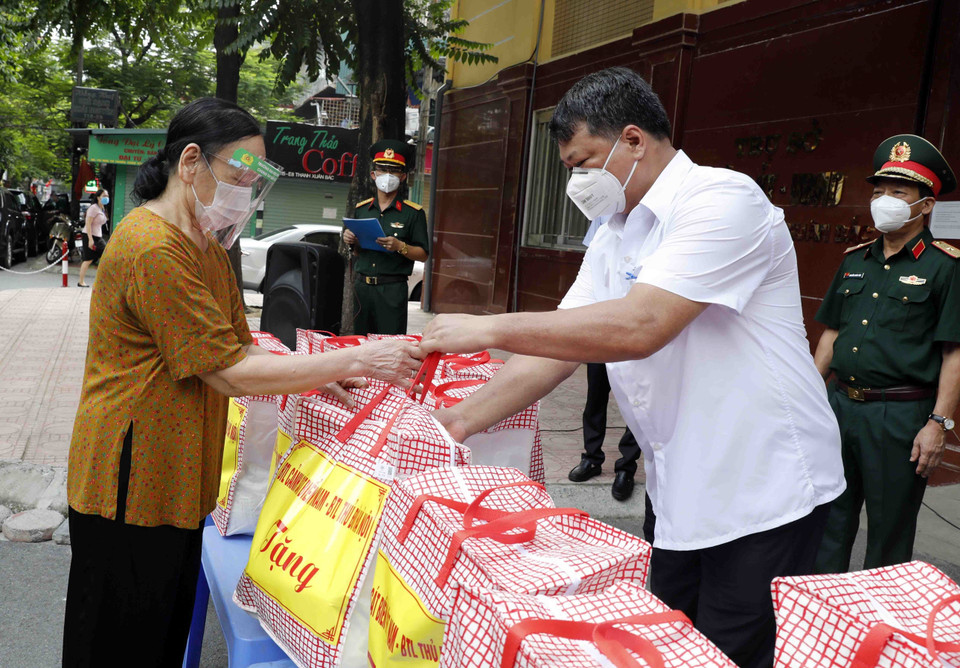 Đại diện hộ gia đình có hoàn cảnh khó khăn phường Thanh Xuân Bắc nhận những món quà từ Bộ Tư lệnh Cảnh sát biển và Bộ Tư lệnh Thủ đô. (Ảnh: Trần Việt/TTXVN)
