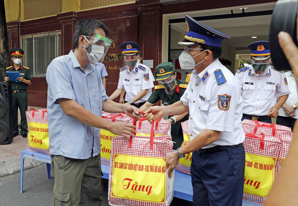 Đại diện hộ gia đình có hoàn cảnh khó khăn phường Thanh Xuân Bắc nhận những món quà từ Bộ Tư lệnh Cảnh sát biển và Bộ Tư lệnh Thủ đô. (Ảnh: Trần Việt/TTXVN)