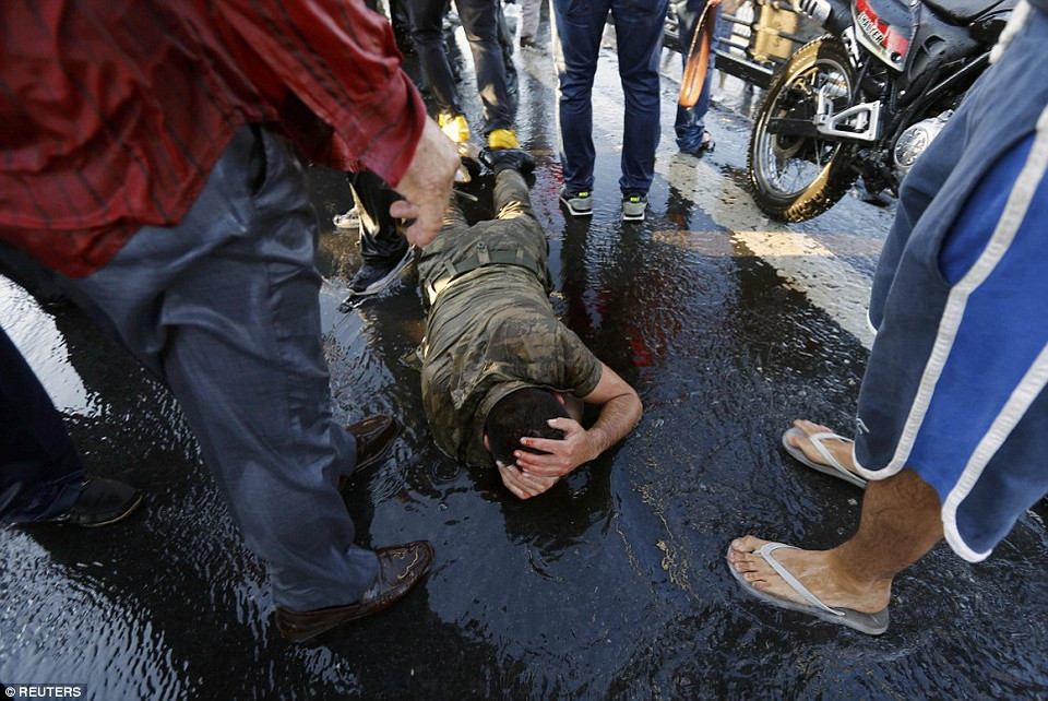 Một người lính nằm co người lại tại khu vực cầu Bosphorus khi đối mặt với cảnh sát mặc thường phục và người dân sau khi đảo chính thất bại. (Nguồn: DailyMail)