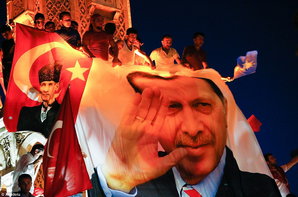 Người dân leo lên đỉnh của tượng đài ở thành phố ven biển Izmir để treo một poster khổng lồ của ông Erdogan. (Nguồn: DailyMail)